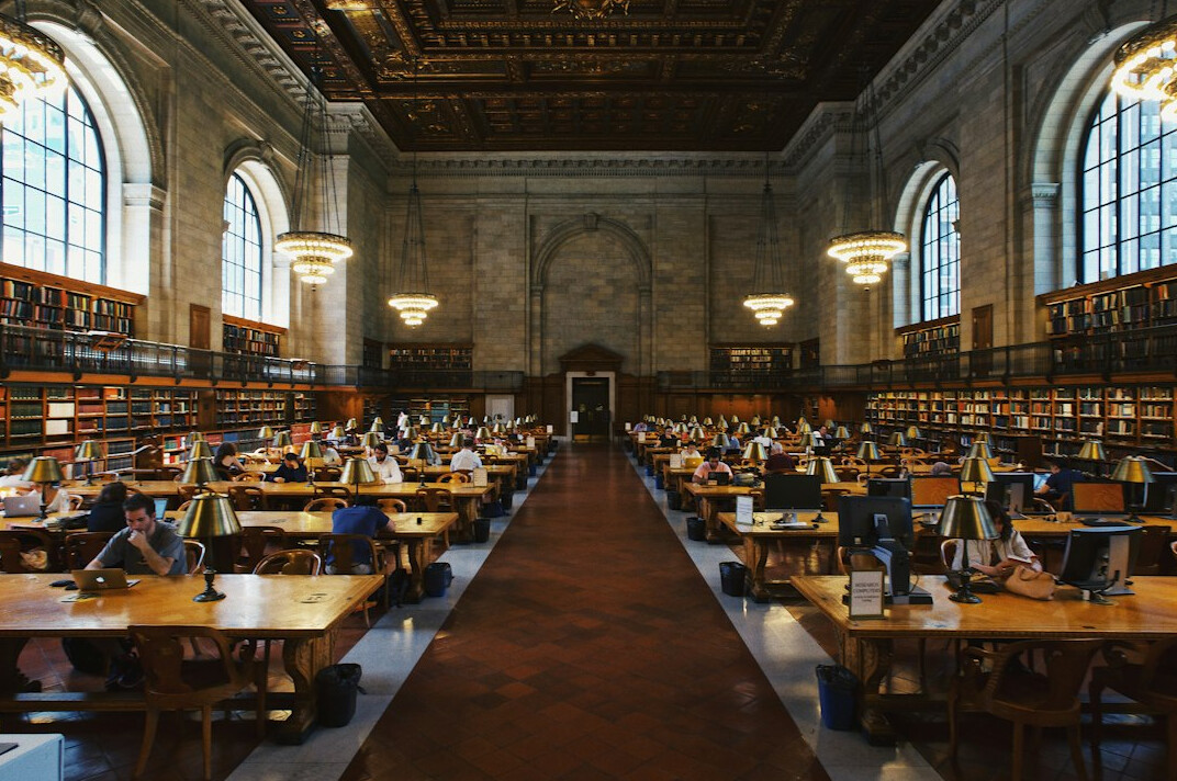 Grand historic library reading room with rows of books